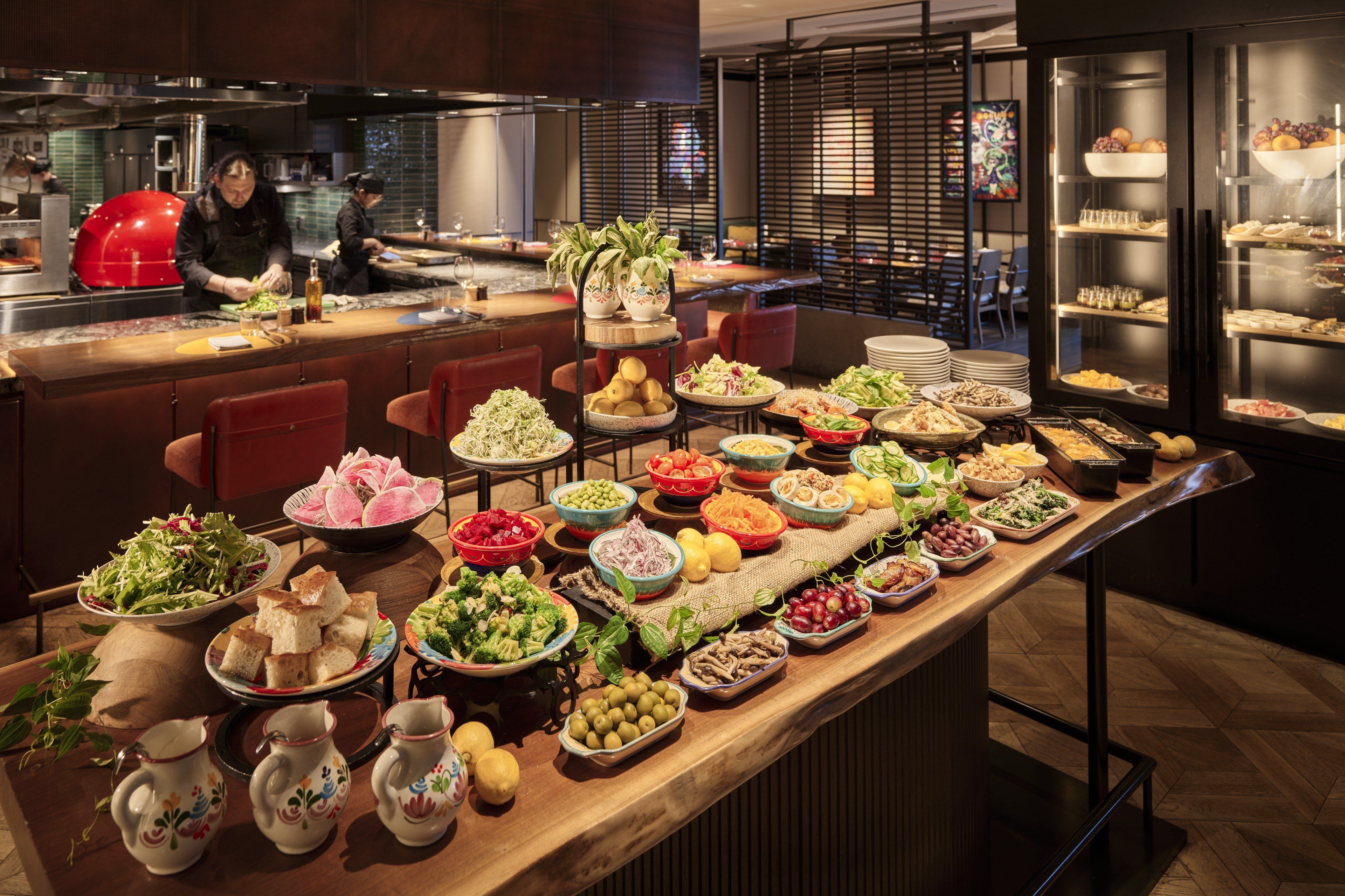 A buffet setup with various food items and a kitchen area in the background.