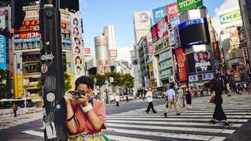 A busy urban street scene with pedestrians crossing a zebra crossing.