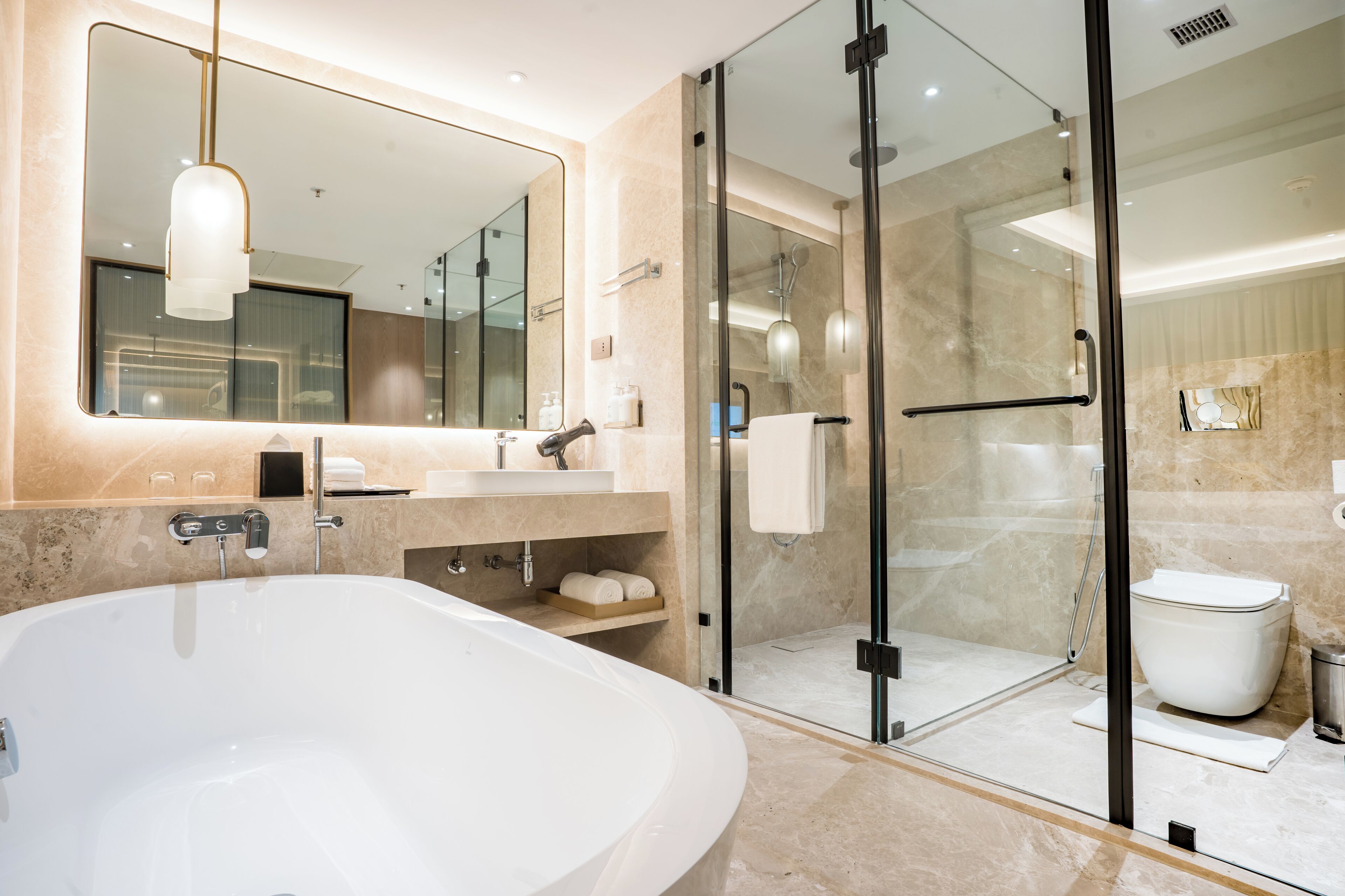 Un bagno moderno con una vasca da bagno ampia, una cabina doccia in vetro e un mobile lavabo con specchio e lavandino.