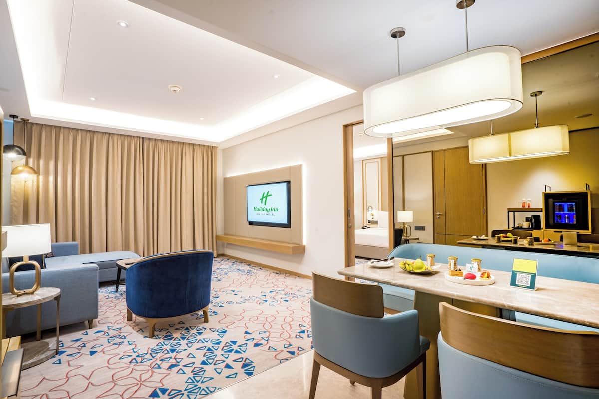 Eine Hotelhalle mit Sitzgelegenheit, einer Rezeption und einem großen Bildschirm, der den Namen des Hotels zeigt.
