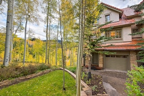 A two-story house with a red-tiled roof, a stone facade, and a garage. - Aspen Ridge 3 3 Bedroom Townhouse by Alpine Lodging Telluride (Telluride)