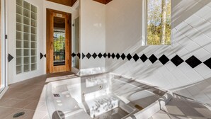 A spa area with a glass-enclosed hot tub, wooden ceiling, and a view of trees through a window. - The Mountain Retreat 3 Bedroom Townhouse by Alpine Lodging Telluride (Telluride)