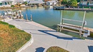 A waterfront property with a dock, a boat, and a marina.