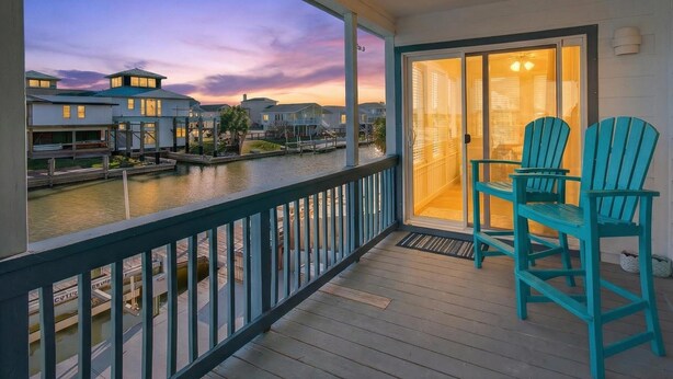 A balcony with a view of a waterfront and houses.
