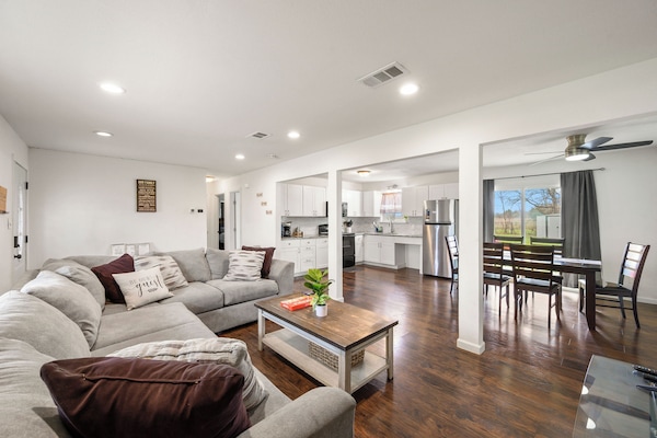 Settle into your spacious living room where comfortable sectional seating flows seamlessly into the bright modern kitchen and dining area.