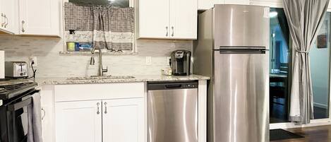 Een koelkast met diepvriezer, een microgolfoven, een oven