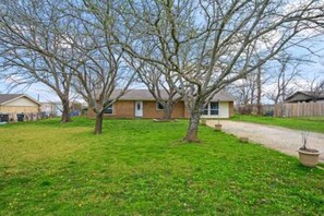 A residential property with a lawn, a pathway, and a detached house. - FW Monthly + WiFi + Desk + Pet Backyard (Fort Worth)