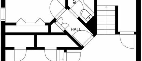 En planritning som visar ett sovrum, badrum, hall, entré och garage.