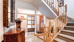 Un escalier avec des balustrades en bois et des marches recouvertes de moquette, menant à un palier.
