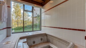 Ein Badezimmer mit großem Fenster, einer Badewanne und einem Handtuchhalter.
