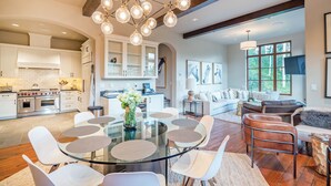 A spacious kitchen with modern appliances, a dining area with a glass table, and a cozy living room with a fireplace. - Mt Wilson Basecamp 4 Bedroom Condo by Alpine Lodging Telluride (Telluride)