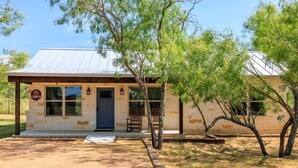A cabin with a metal roof, a wooden porch, and a sign indicating it is Cabin 9. - Lone Star Cabin No. 9 (Fredericksburg)