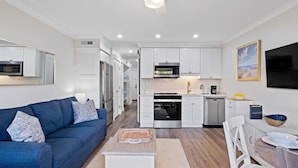 A modern kitchen with white cabinets, a built-in microwave, and a dishwasher.