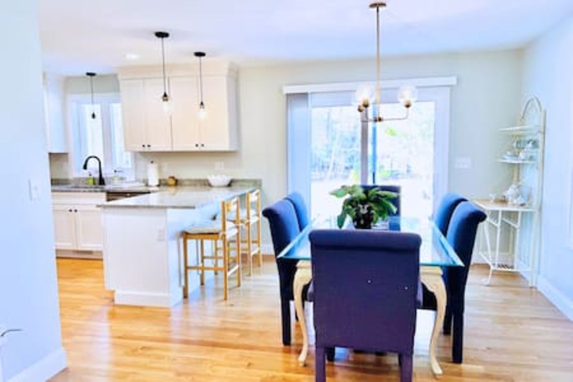 A modern kitchen with wooden cabinets, a central island, and pendant lighting.