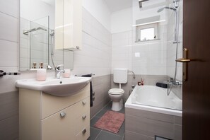 Ein modernes Badezimmer mit Waschbecken, Toilette und Badewanne.