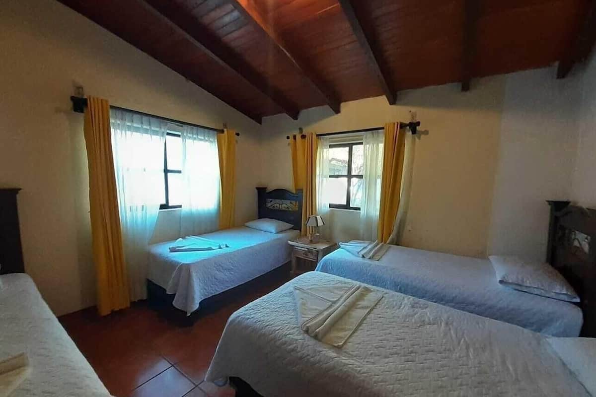 A room with two beds, a small table, and a television.