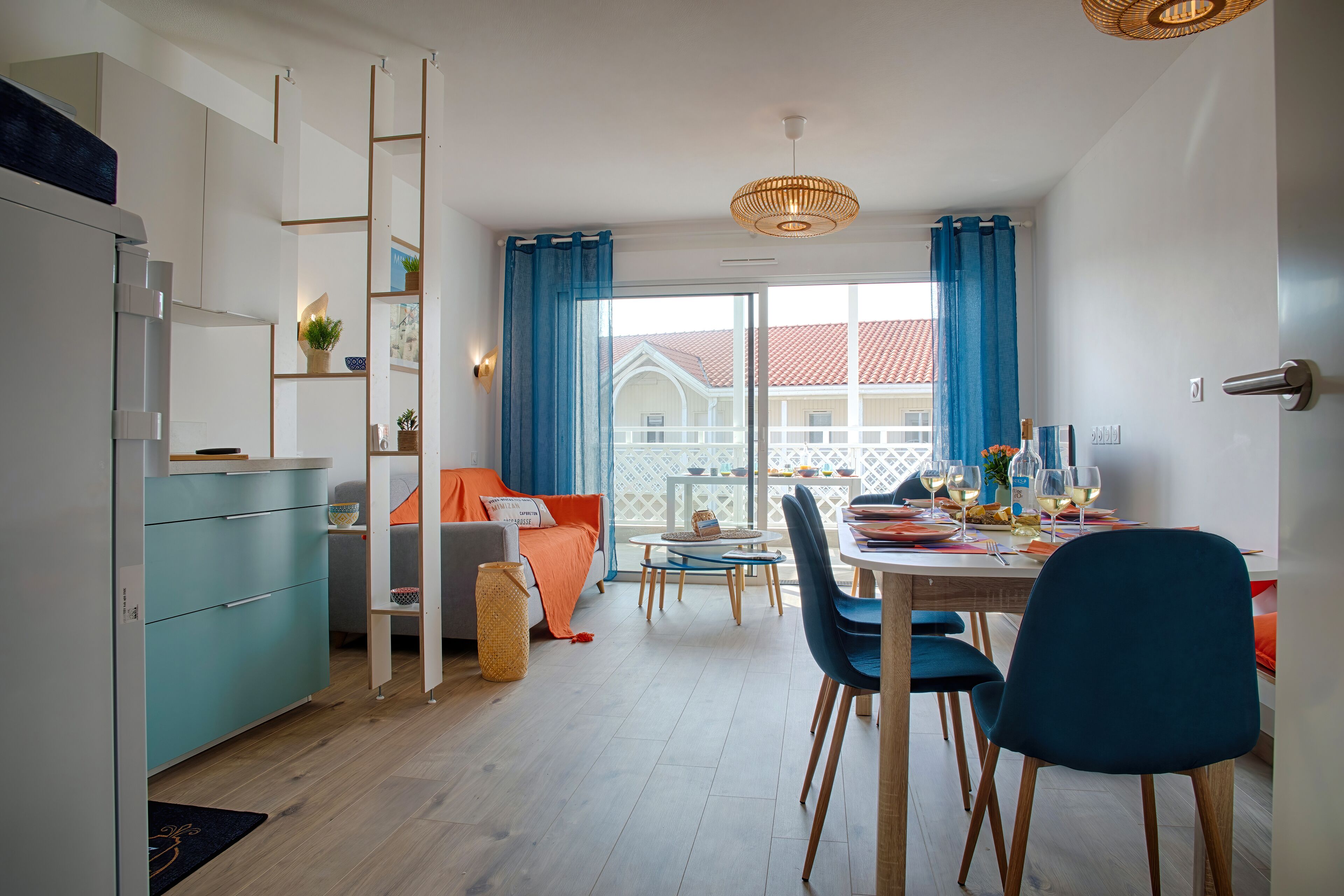 Een moderne woonkamer met een eetgedeelte, met een bank, een gedekte tafel en uitzicht op buiten.