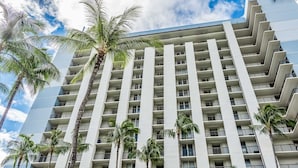 A high-rise hotel with multiple balconies and palm trees. - Hawaiian Princess at Makaha Beach (Waianae)