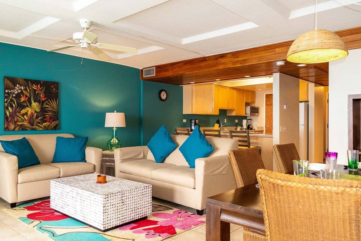 A living room with a sofa set, a coffee table, and a dining area with a table and chairs.