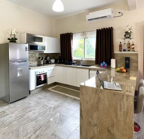 Enjoy cooking in this well-equipped kitchen with an oven, refrigerator, and microwave.