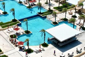 Relax by the pool surrounded by palm trees and sun loungers.
