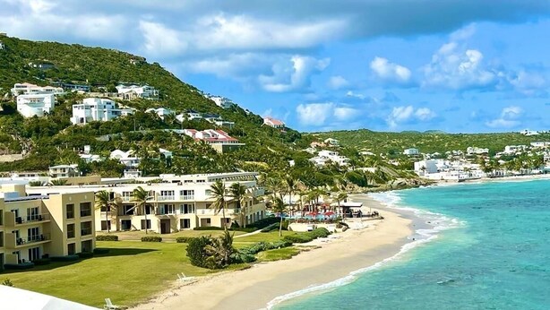 A coastal hotel with multiple buildings, a beach, and a mountainous backdrop. - Dawn Beach Club Villa. With Beach access.  (Philipsburg)
