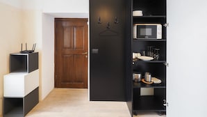 Una cocina moderna con microondas, armarios y una puerta de madera.