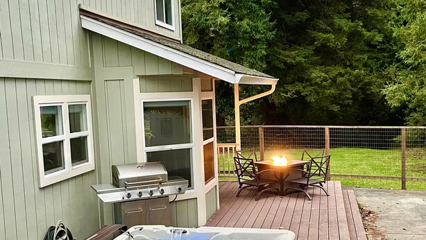 Ein Haus mit Terrasse, Whirlpool und Grill.