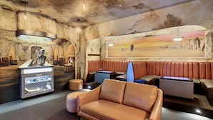 A restaurant with a rustic interior, featuring leather booths, a central table, and a wall mural.