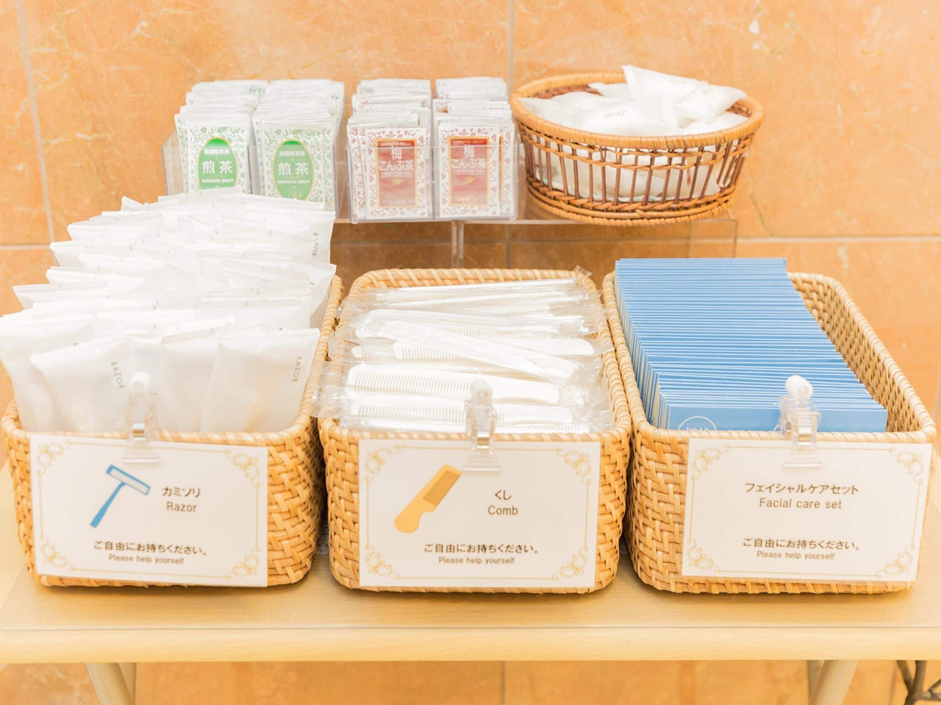 Una exhibición de productos de aseo personal, como navajas, peines y kits de cuidado facial, en cestas de mimbre.