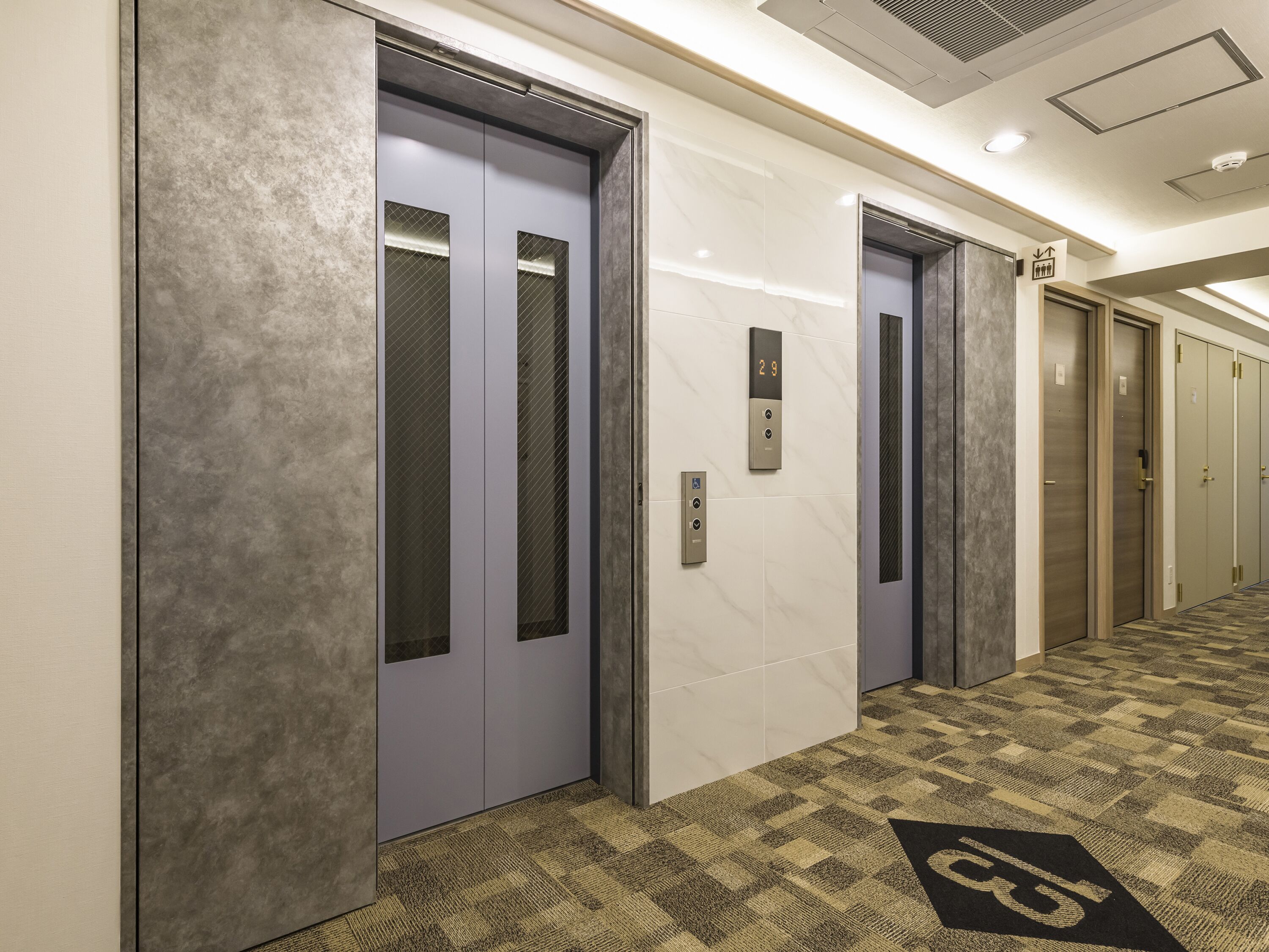 A hallway with two elevators, one marked with the number 29.