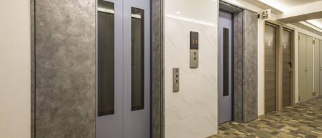 A hallway with two elevators, one marked with the number 29.