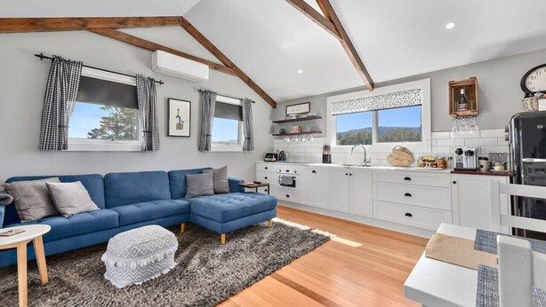 A modern kitchen with white cabinets, a black refrigerator, and a window with checkered curtains. - Wakefields - an enchanting mountain view cottage (Mole Creek)