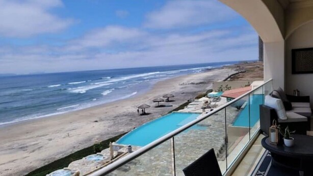 Un balcon avec vue sur la plage et l’océan.
