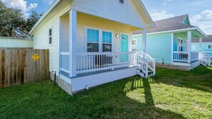 A single-story house with a front porch, a small deck, and a fenced yard.
