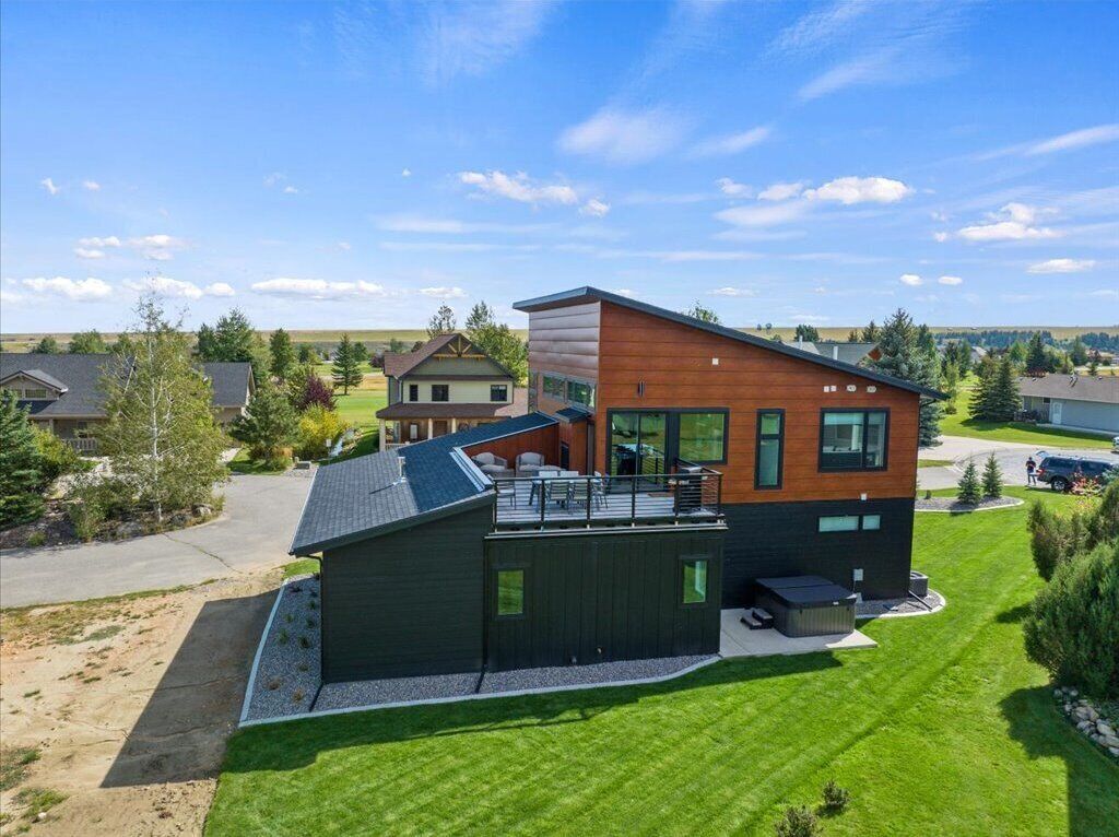 A modern two-story house with a deck and a separate garage.