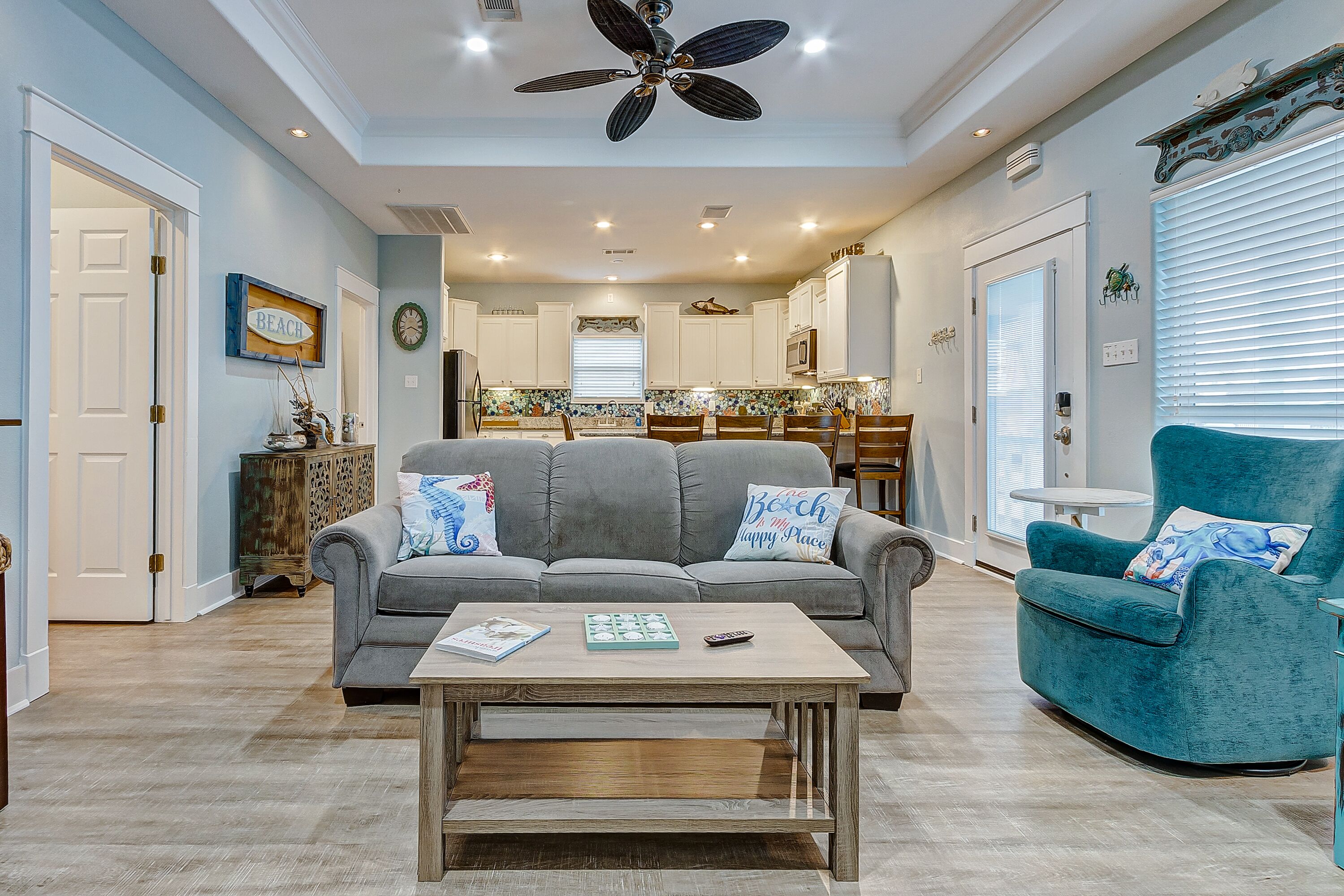 A living room with a grey sofa, teal armchair, and a coffee table.