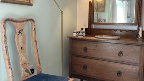 A room with a vintage chair, a wooden dresser with drawers, a floor lamp, and a framed picture on the wall. - A cosy retreat, ideal for walks and quiet relaxation. Pet friendly! (Brampton)