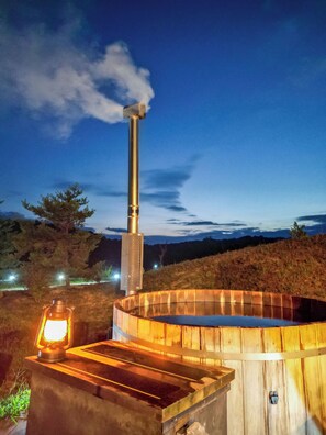 Relax in a secluded hot tub under the stars, surrounded by nature.