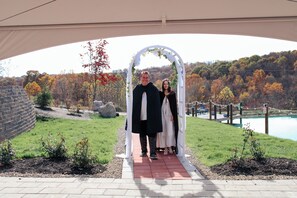 Couples can exchange vows under a beautiful archway surrounded by lush trees and a serene body of water.