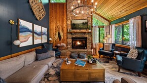 A cozy living room with a stone fireplace, leather sofas, and a wooden ceiling. - Luxe Cabin, Dollywood, 4 min to Pkwy, Pups Welcome (Pigeon Forge)