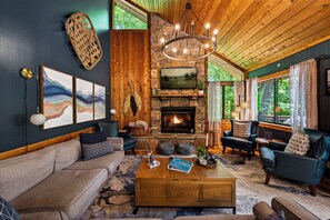 A cozy living room with a stone fireplace, leather sofas, and a wooden ceiling. - Luxe Cabin, Dollywood, 4 min to Pkwy, Pups Welcome (Pigeon Forge)