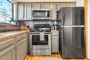 Enjoy cooking in this well-equipped kitchen with a microwave, oven, and refrigerator.