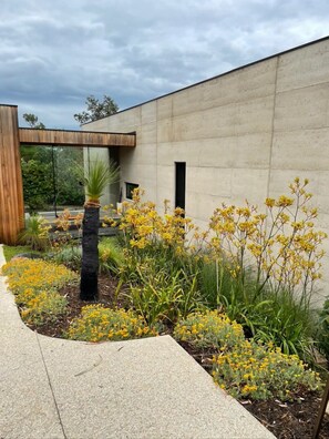 Stroll through lush gardens featuring a pergola and vibrant plants.