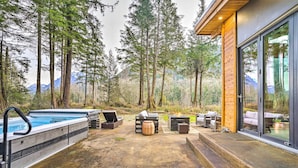 Een zwembadgedeelte met een jacuzzi, ligbedden en een rustiek houten terras.