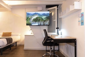 Relax in a stylish room with a comfortable bed, desk, and flat-screen TV featuring a scenic view.