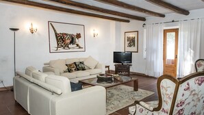 Un saló amb un sofà, una taula de centre i una televisió.