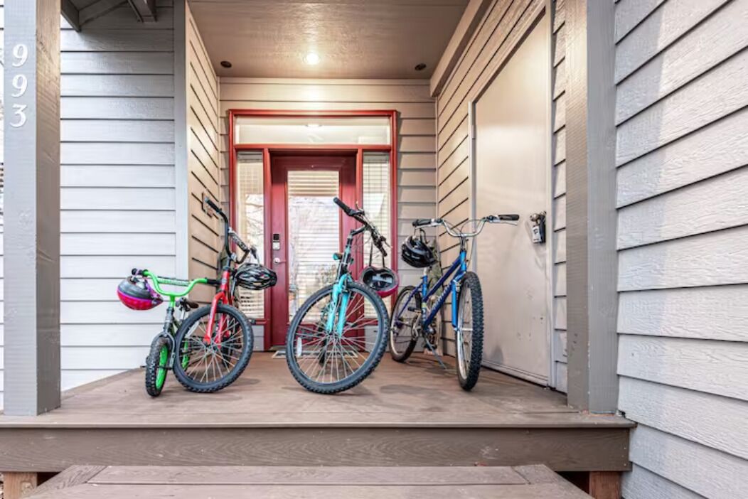 A porch with three bicycles parked.