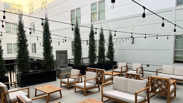 An outdoor seating area with wooden furniture and string lights. - Downtown Memphis Loft! Walking distance from Beale street! Garage parking! (Memphis)