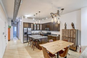 A modern kitchen with a central island, stainless steel appliances, and pendant lighting. - Lovely 2-Bedroom Unit in Springfield (Springfield)